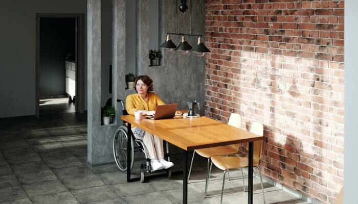 mulher de cadeira de rodas em sua casa trabalhando no home office